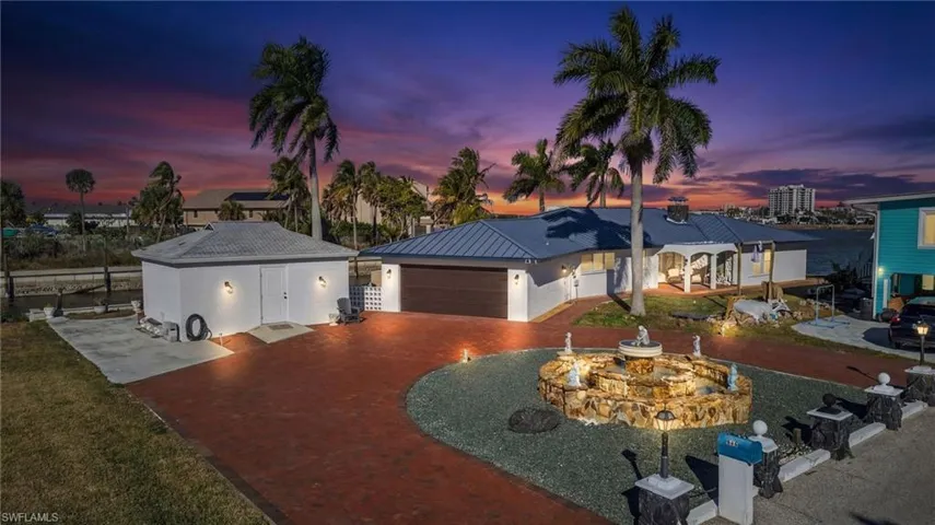 View of front of home featuring driveway, an attached garage, and stucco siding