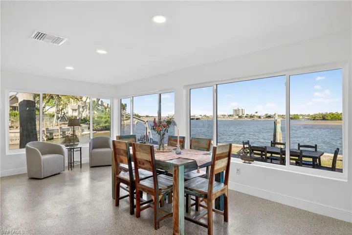 Sunroom featuring a water view, recessed lighting, and speckled floor