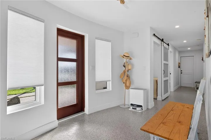 Entrance foyer with a barn door, dark speckled floor, and recessed lighting