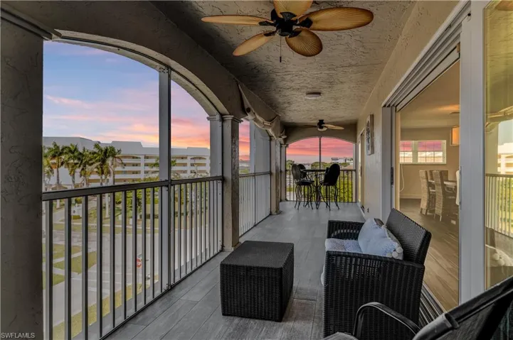 Spacious screened balcony featuring tile flooring and two ceiling fans