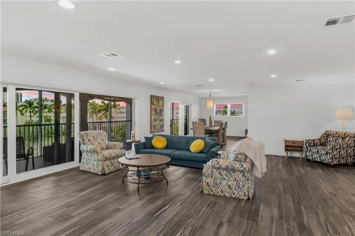 Expansive living area with wood-finish flooring, recessed lighting, and crown molding