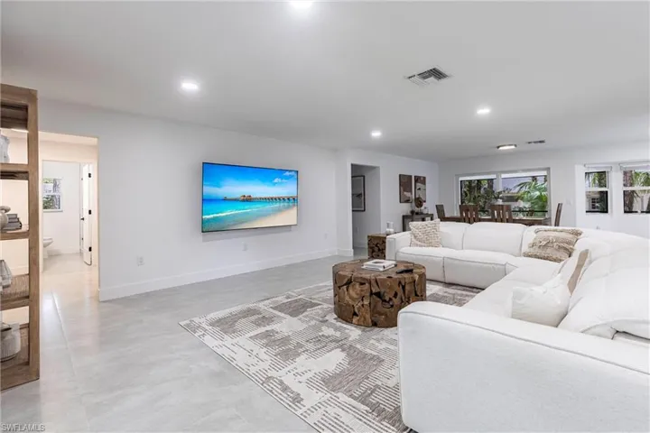 Living area featuring recessed lighting and finished concrete floors