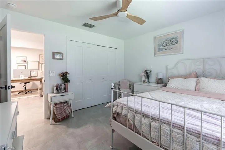 Bedroom with an office area, a closet, and a ceiling fan