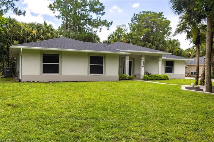 Ranch-style house with stucco siding, a front yard, and a shingled roof