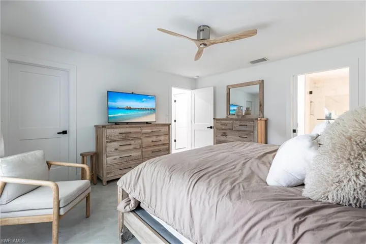 Bedroom with ceiling fan and finished concrete flooring
