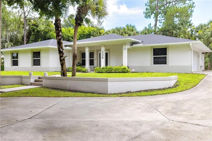 Single story home featuring concrete driveway, roof with shingles, a front yard, and stucco siding