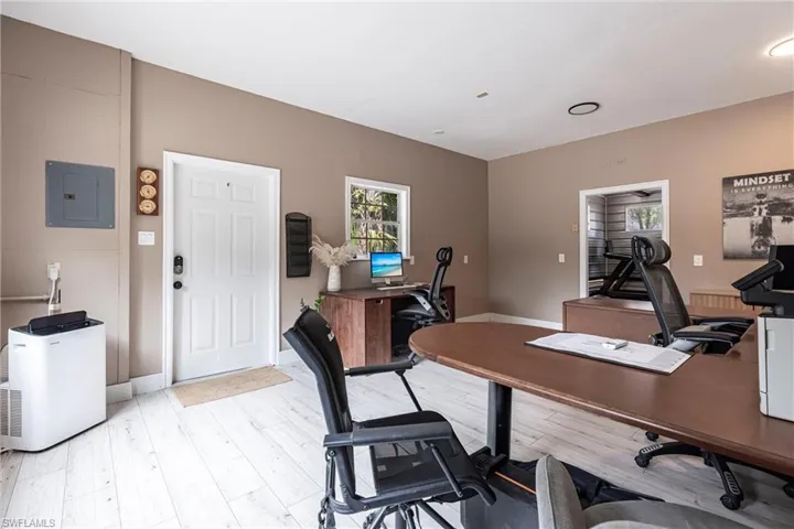 Outside Office area featuring electric panel and light wood-style floors