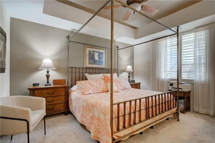 Bedroom with a textured ceiling, ceiling fan, and light carpet