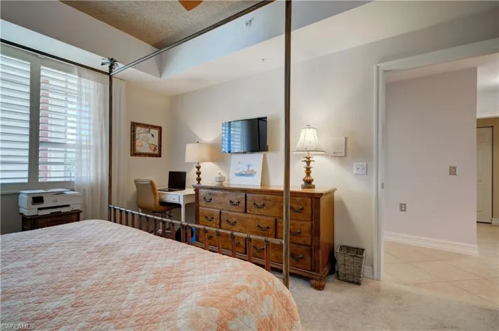 Carpeted bedroom with ceiling fan and a textured ceiling