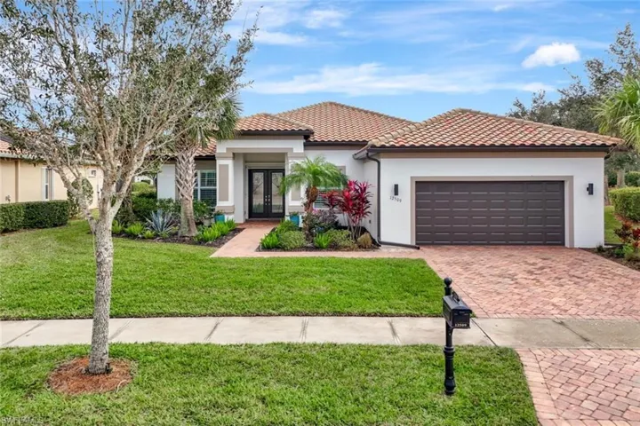 Mediterranean / spanish-style home with french doors, a garage, and a front yard