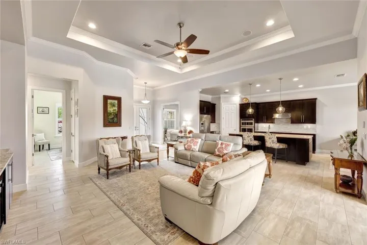 Living room with a tray ceiling and ornamental molding