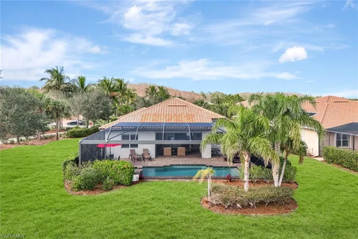 View of pool with a patio, a yard, and glass enclosure