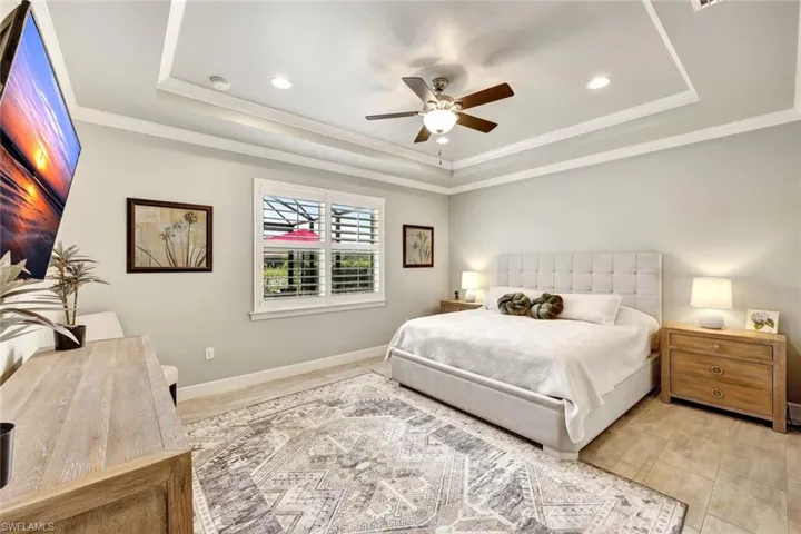 Bedroom featuring crown molding, ceiling fan, and a tray ceiling