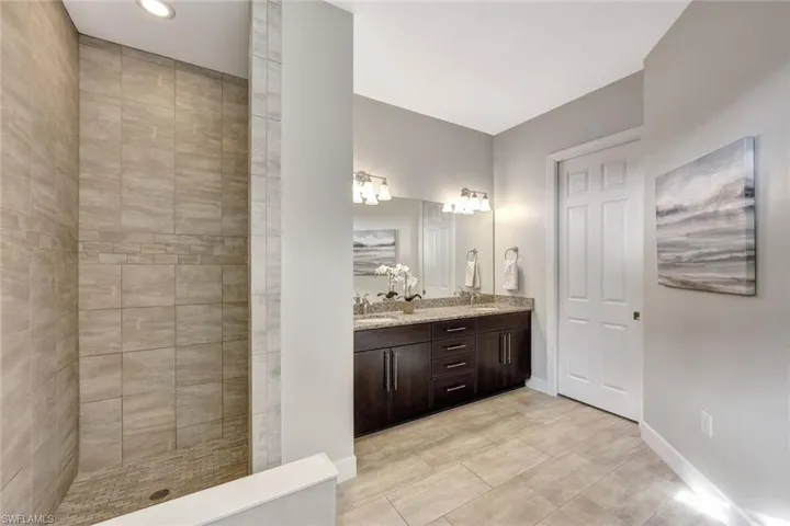 Bathroom with vanity and tiled shower