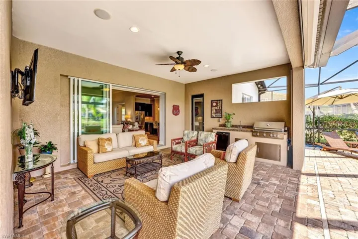 View of patio / terrace featuring area for grilling, an outdoor living space, a lanai, and ceiling fan
