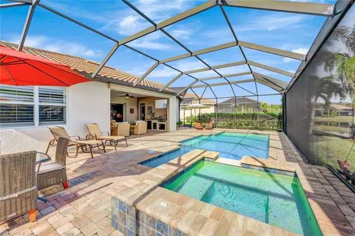 View of pool with a patio, exterior kitchen, an in ground hot tub, a lanai, and ceiling fan