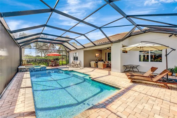 View of pool featuring an in ground hot tub, ceiling fan, glass enclosure, and a patio
