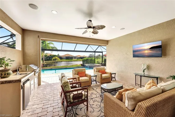 View of patio featuring sink, a lanai, ceiling fan, outdoor lounge area, and area for grilling