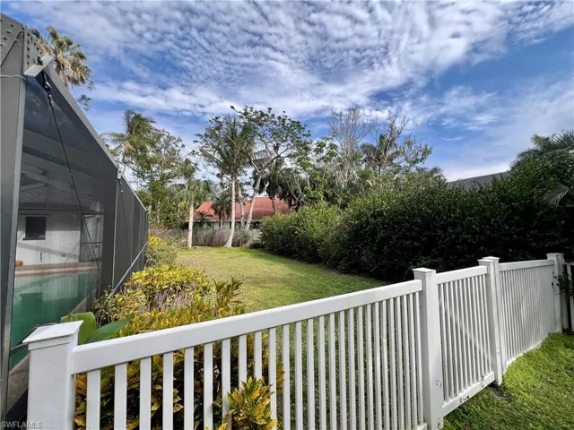 View of yard with white PVC fencing.
