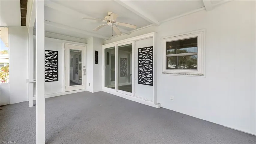 Unfurnished sunroom with a ceiling fan, beam ceiling, and a patio area