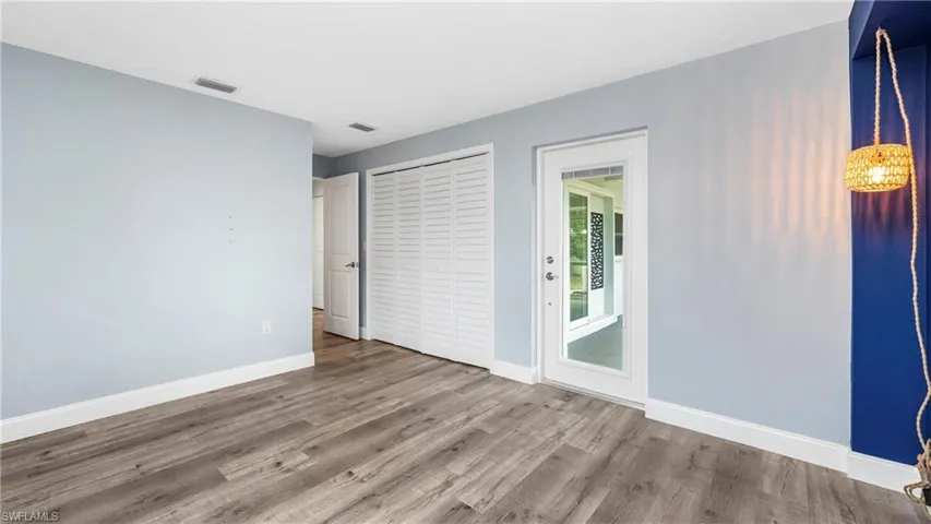 Unfurnished bedroom with dark wood-style floors and a closet