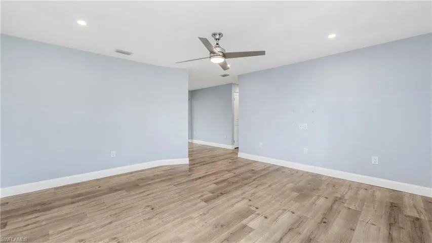 Empty room featuring ceiling fan, light wood-style flooring, and recessed lighting