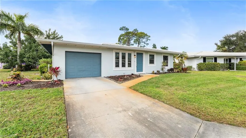 Ranch-style home with a front lawn, stucco siding, a garage, and concrete driveway