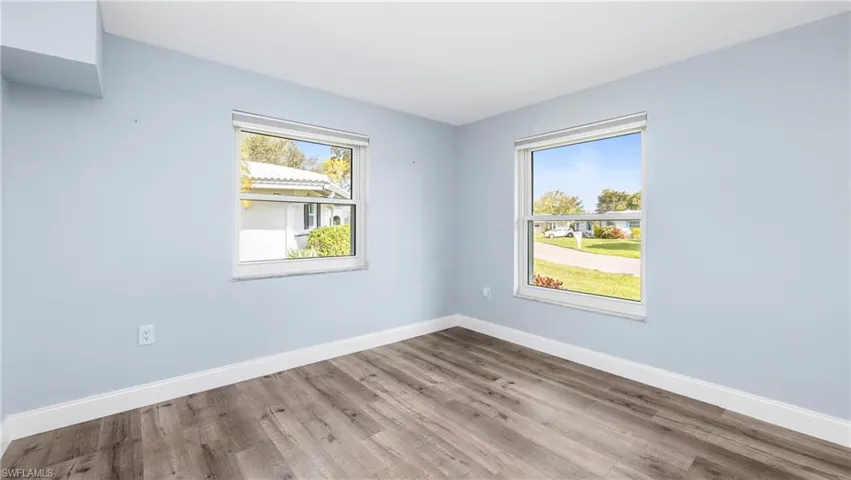 Empty room with light wood-style flooring and baseboards