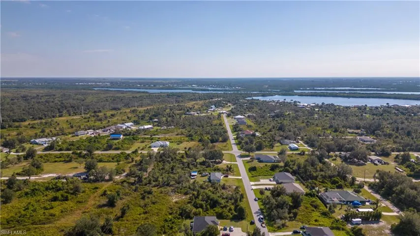 Aerial overview of property's location featuring a large body of water and nearby suburban area