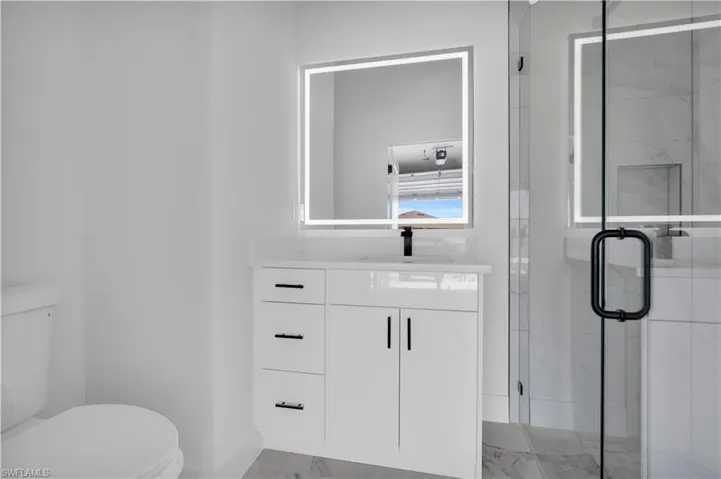 Contemporary bathroom vanity with a white countertop, undermount sink, and matte black faucet