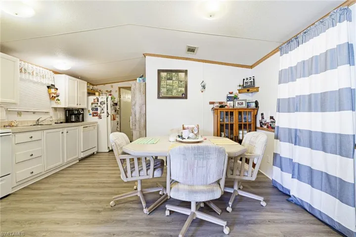 Dining area featuring vaulted ceiling and light wood-style floors