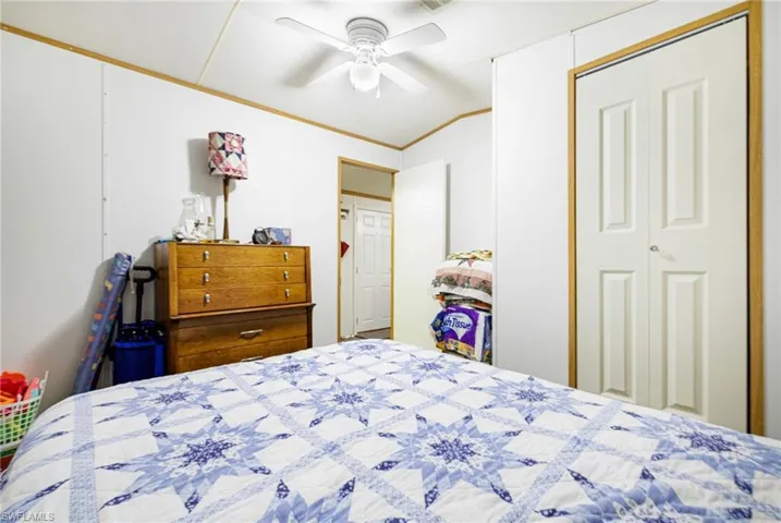 Guest bedroom with lofted ceiling, ornamental molding, and ceiling fan