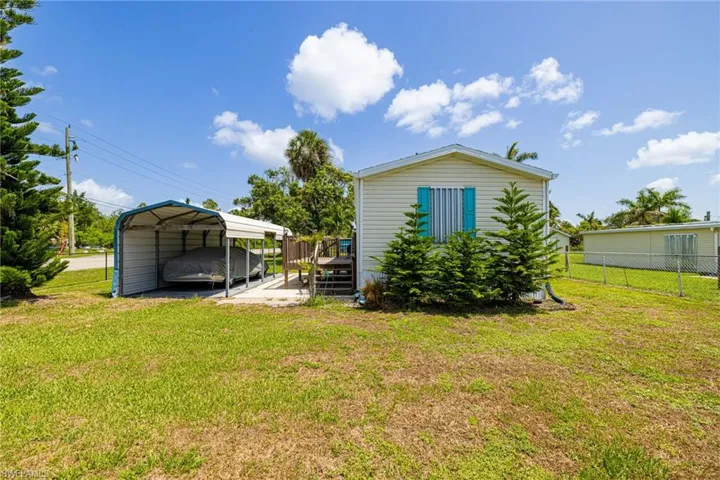 Back of property featuring a detached carport