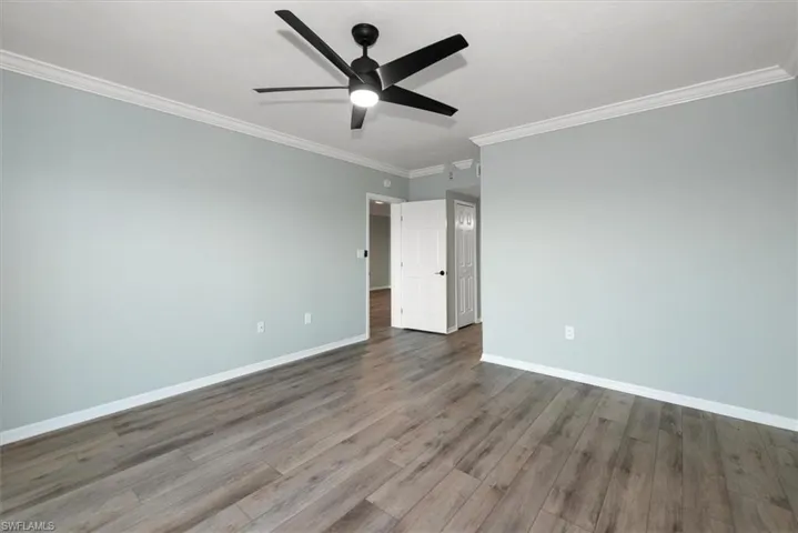 Spare room with ceiling fan, wood finished floors, and ornamental molding