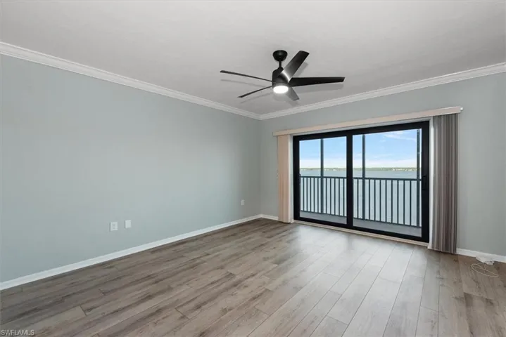 Spare room featuring ornamental molding, ceiling fan, wood finished floors, and a water view
