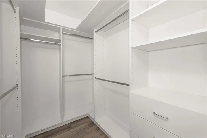 Spacious closet featuring dark wood-type flooring