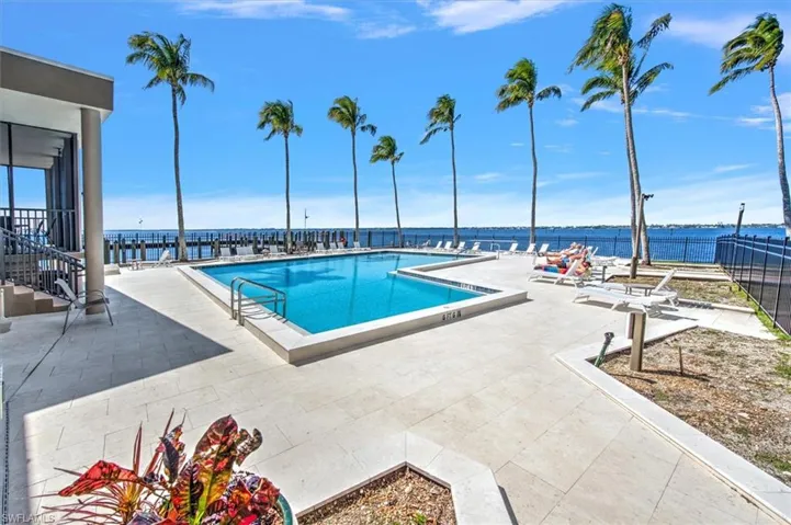 Community pool featuring a patio and a water view