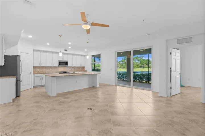 Kitchen with decorative backsplash, visible vents, ceiling fan, stainless steel appliances, and a healthy amount of sunlight