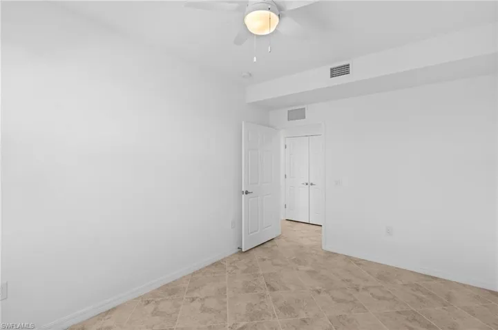 Spare room featuring baseboards, visible vents, and a ceiling fan