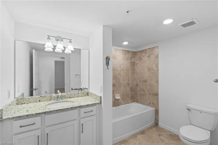 Bathroom featuring tile patterned flooring, vanity, toilet, a chandelier, and visible vents