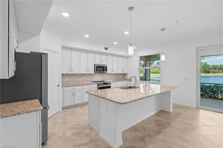 Kitchen featuring white cabinetry, ornamental molding, decorative backsplash, a sink, and appliances with stainless steel finishes