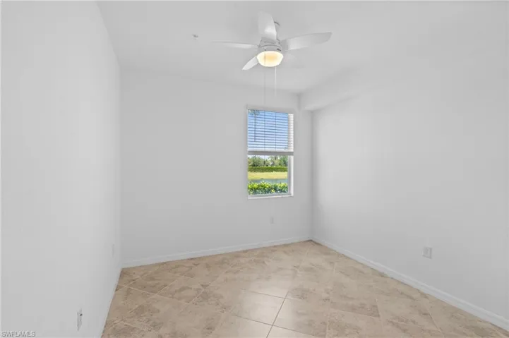 Unfurnished room featuring light tile patterned floors, baseboards, and ceiling fan