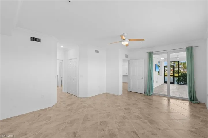Unfurnished room featuring baseboards, visible vents, ornamental molding, and a ceiling fan