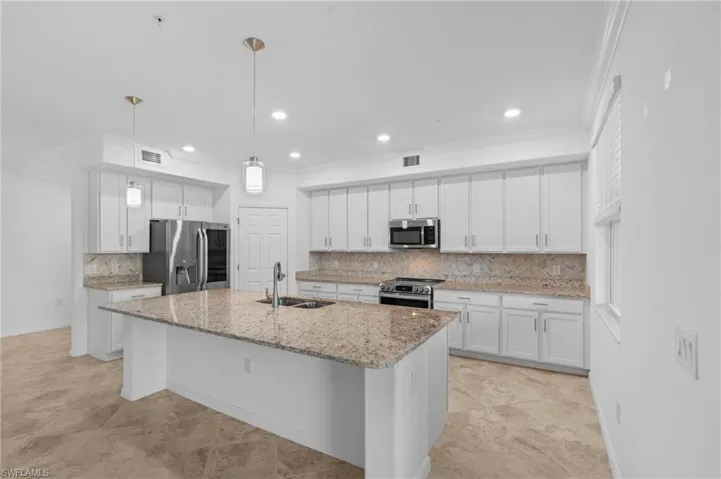 Kitchen featuring white cabinets, a sink, appliances with stainless steel finishes, and visible vents