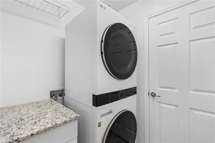 Clothes washing area with stacked washer and clothes dryer and laundry area