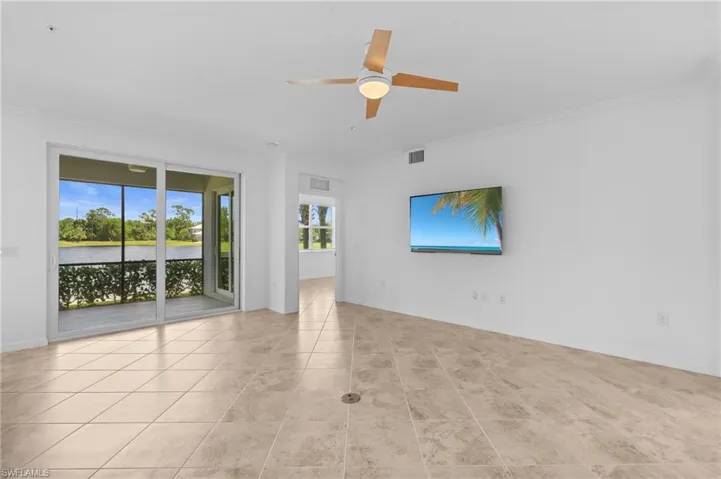Tiled spare room with a ceiling fan, crown molding, baseboards, and visible vents