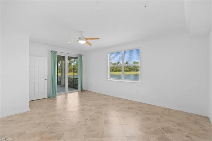 Unfurnished room featuring a ceiling fan, light tile patterned flooring, crown molding, and baseboards