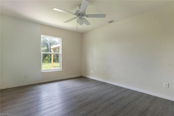 Empty room with hardwood / wood-style floors and ceiling fan
