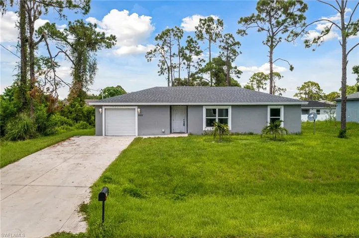 Ranch-style house with a front lawn and a garage