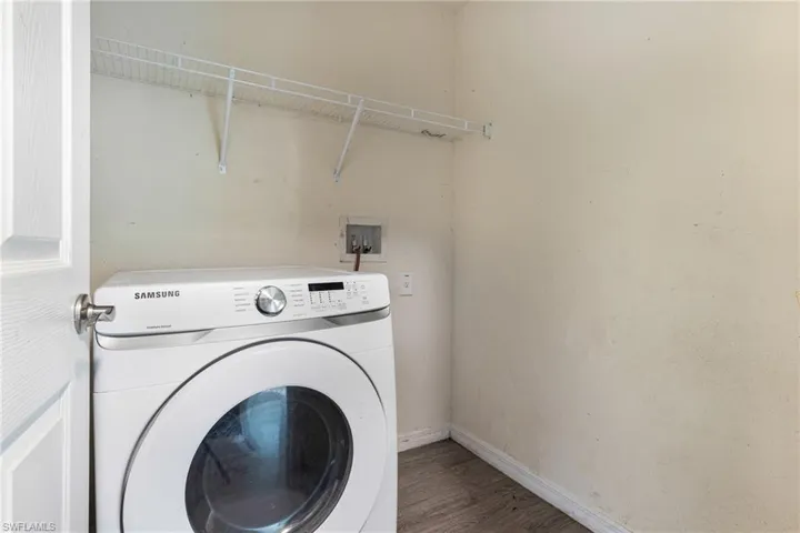 Laundry area featuring hardwood / wood-style floors and washer / dryer